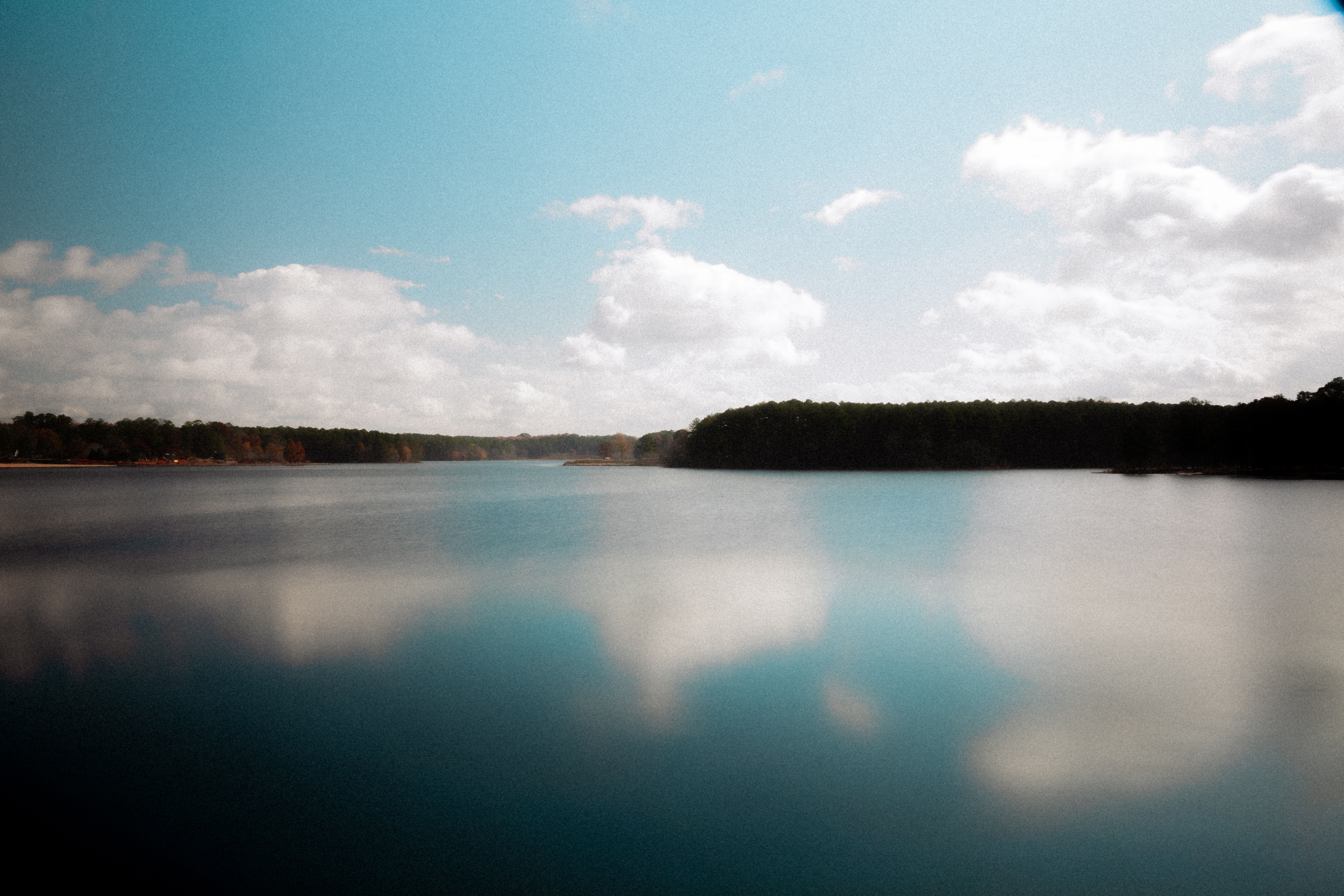 Tranquil Lake with Reflections Under Blue Skies · Free Stock Photo