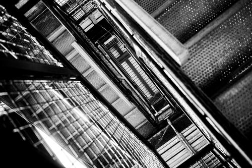 Free Dramatic black and white view of an industrial staircase with artistic lines and angle. Stock Photo