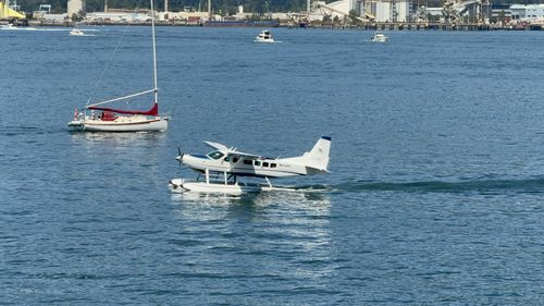 Free A seaplane and sailing boat on a sunny day at a harbor. Stock Photo