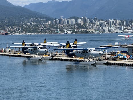 Seaplanes docked at Vancouver waterfront with city skyline in background.