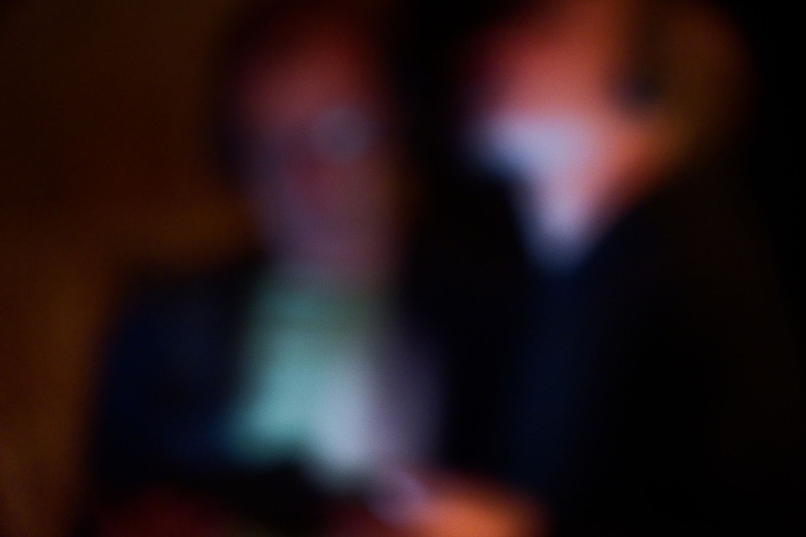 Silhouettes floues et abstraites de deux personnages dans une lumière chaude tamisée