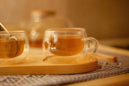 Free Elegant glass teacups filled with herbal tea on a wooden tray, creating a warm, cozy atmosphere. Stock Photo