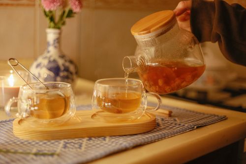 Free Warm indoor setting with tea being poured and candlelight for a cozy atmosphere. Stock Photo