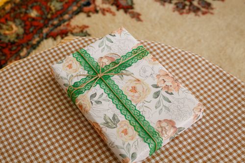 Free Floral gift box with green lace on a gingham tablecloth, indoors. Stock Photo