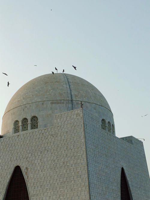 Free Stunning perspective of the iconic Quaid-i-Azam Mausoleum in Karachi, Pakistan, with birds soaring above. Stock Photo