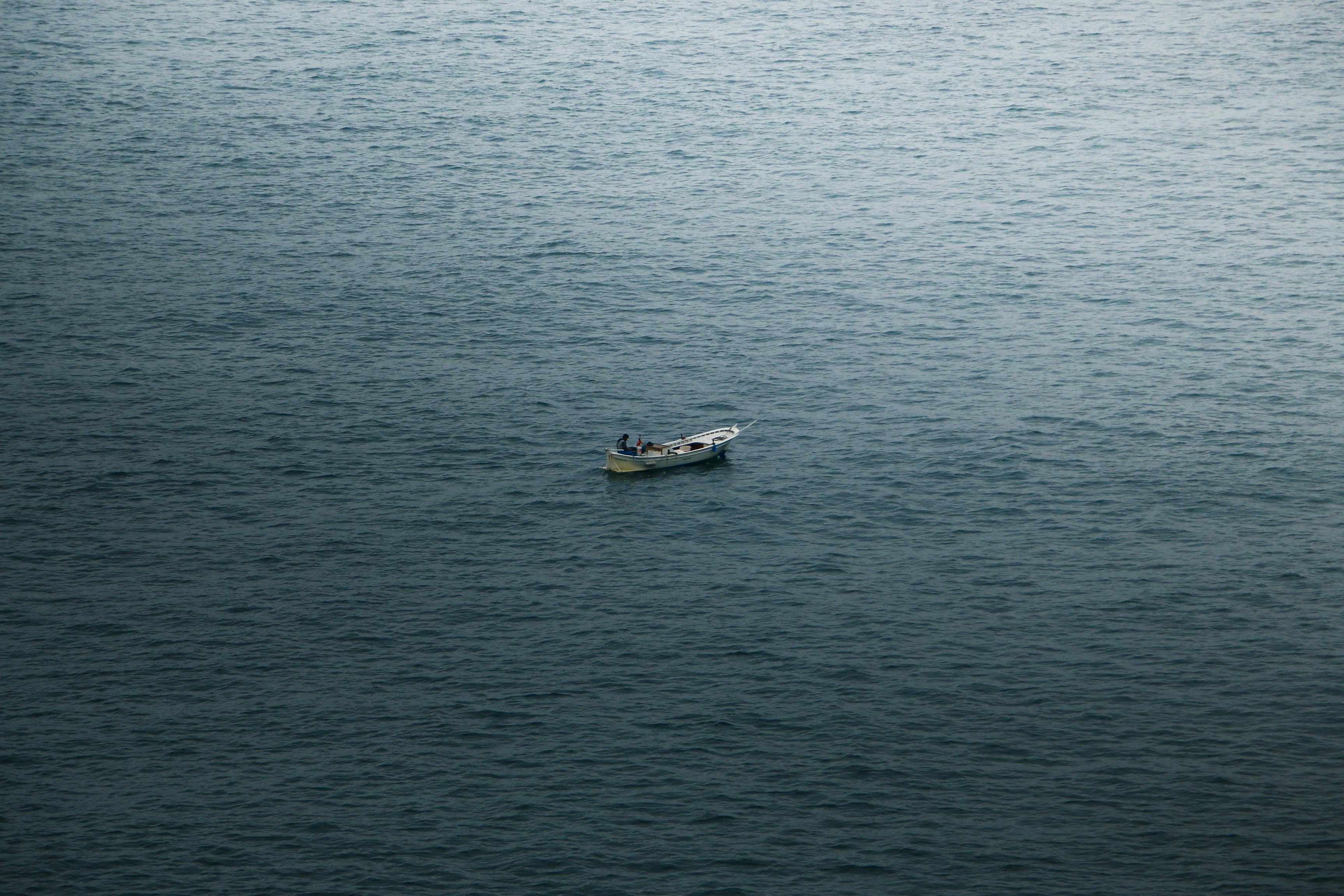 Small fishing boat drifting on the serene sea off Zonguldak, Türkiye, under a cloudy sky.