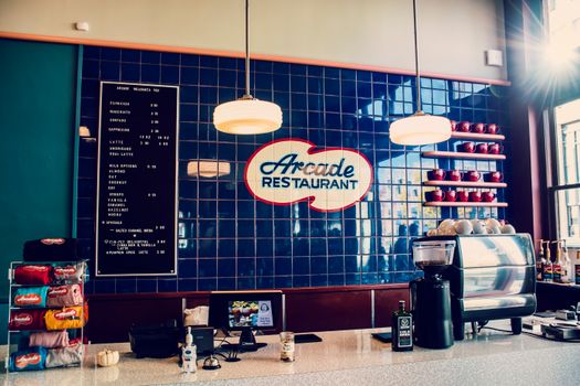 Cozy restaurant interior showcasing a menu board, coffee machine, and stylish decor.