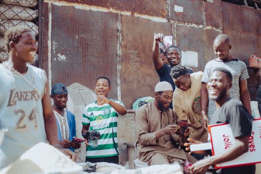 Lively group of diverse men socializing in an urban setting, enjoying a cheerful moment together.