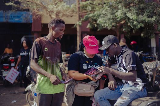 Three adults engaging in conversation outdoors in an urban setting.