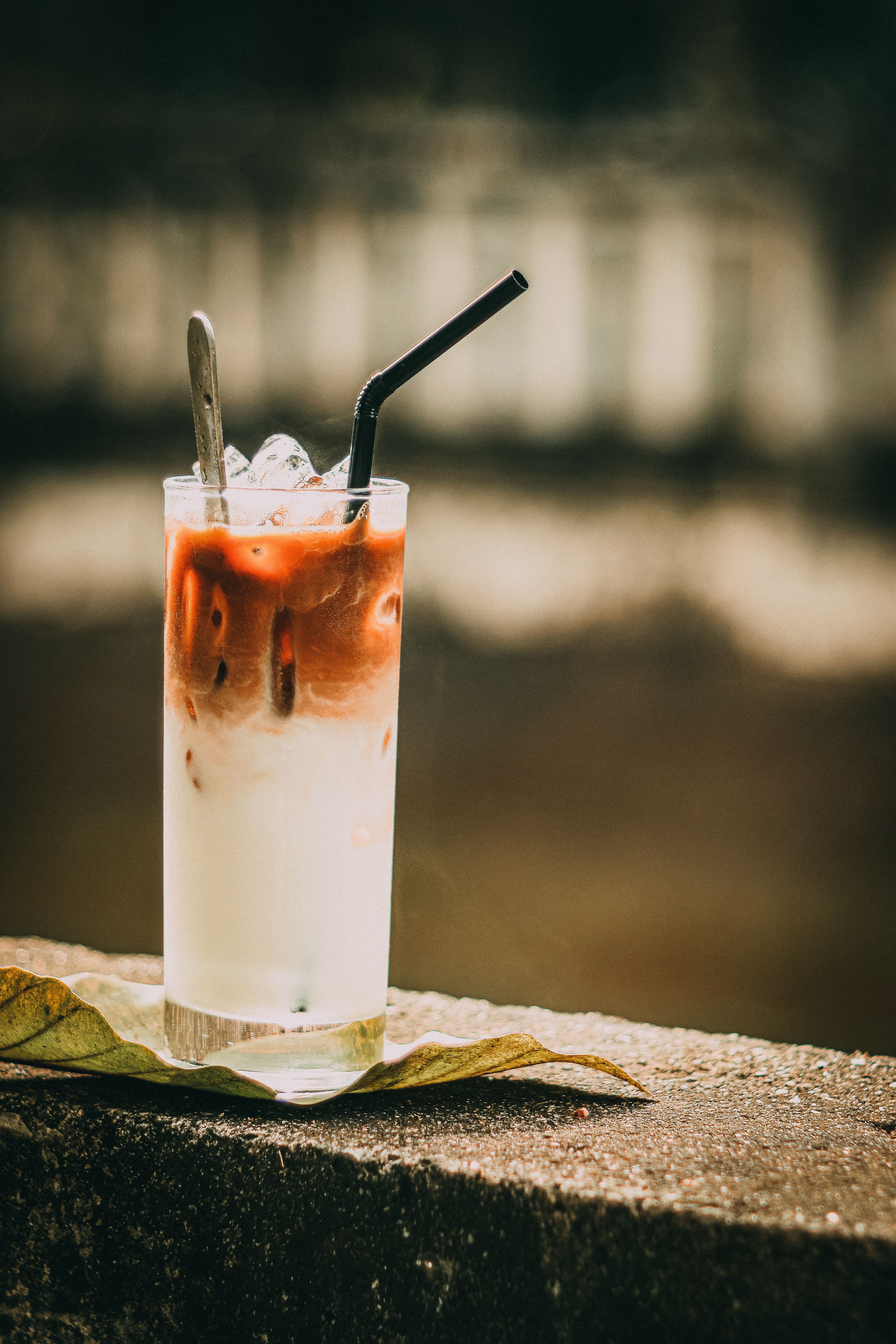 Refreshing iced coffee latte on a sunny day with a scenic blurred background.