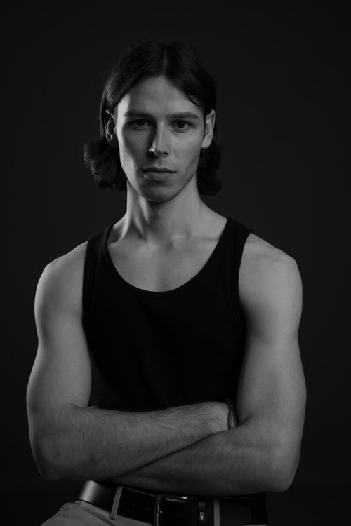 Free Artistic black and white portrait of a young man in a studio setting. Stock Photo
