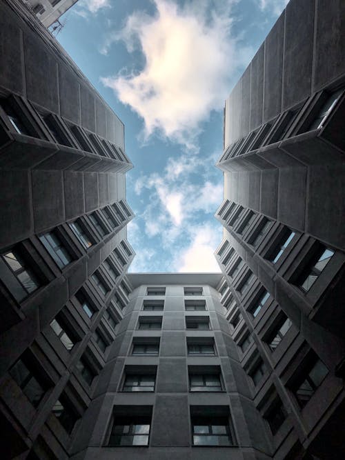 бесплатная Низкоугловая фотография высотного здания под голубым небом Стоковое фото