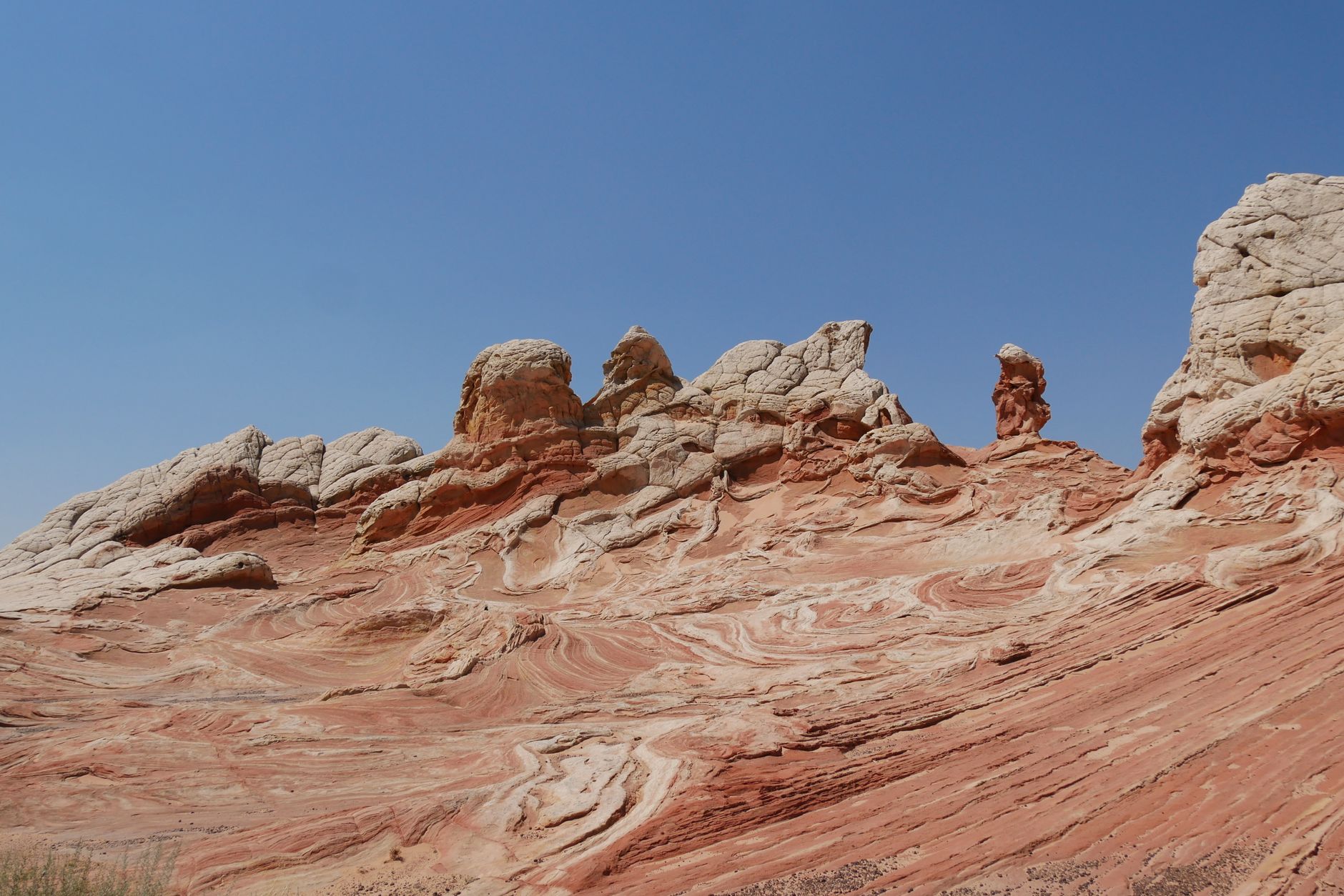 Stunning landscape of red rock formations under a clear blue sky, showcasing natural beauty and erosion patterns.