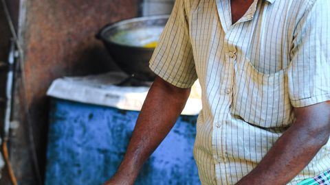 A man prepares traditional flatbreads at a street food stall in Dhaka, Bangladesh.