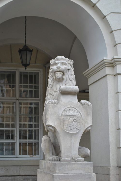Free Elegant stone lion statue guards a historic European building entrance. Stock Photo