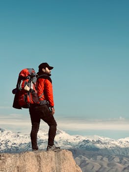 在伊拉克苏莱曼尼亚，一名孤独的徒步旅行者站在悬崖边，俯瞰着雪山