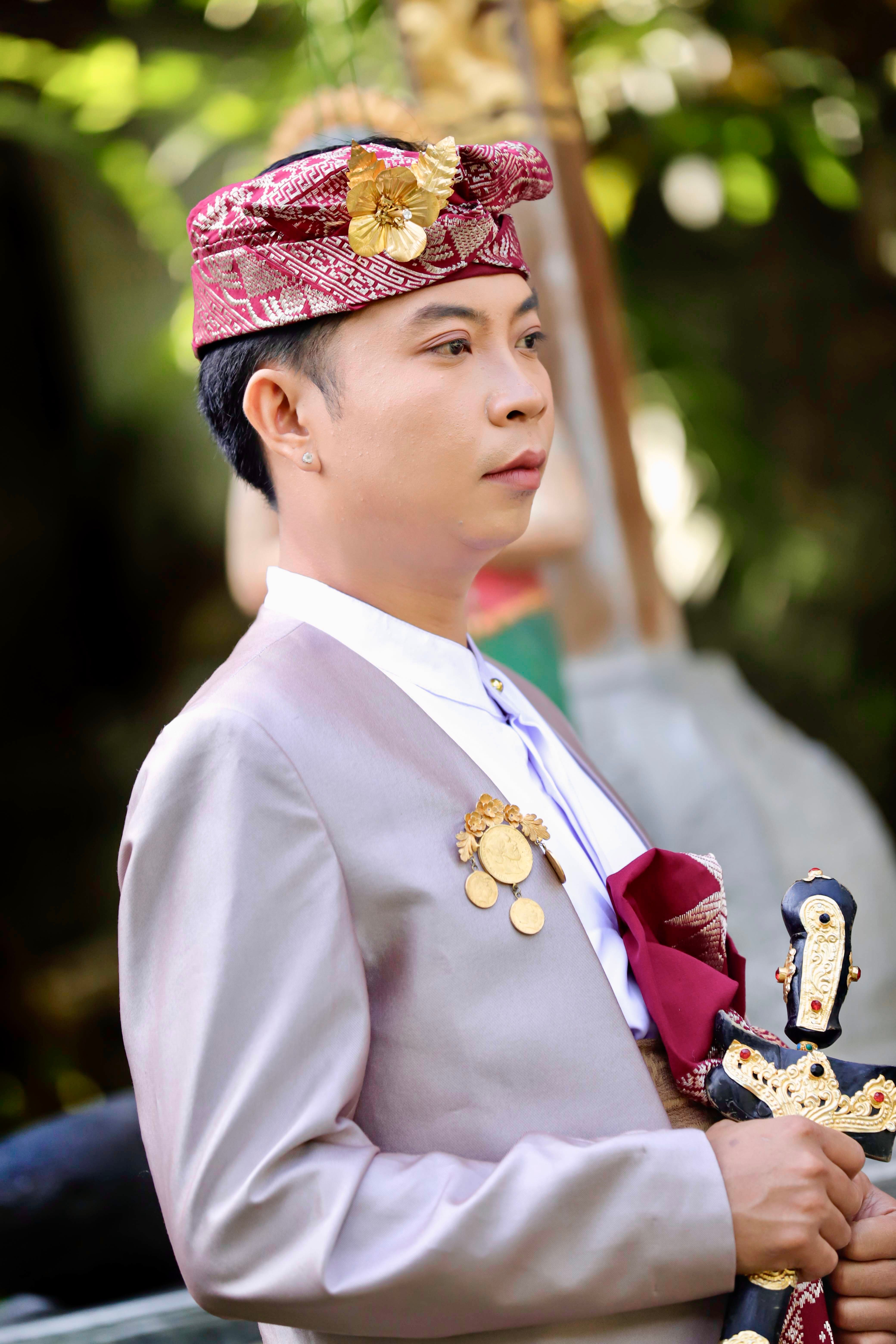 Portrait of a man in traditional Indonesian attire outdoors in Nusa Tenggara Barat.