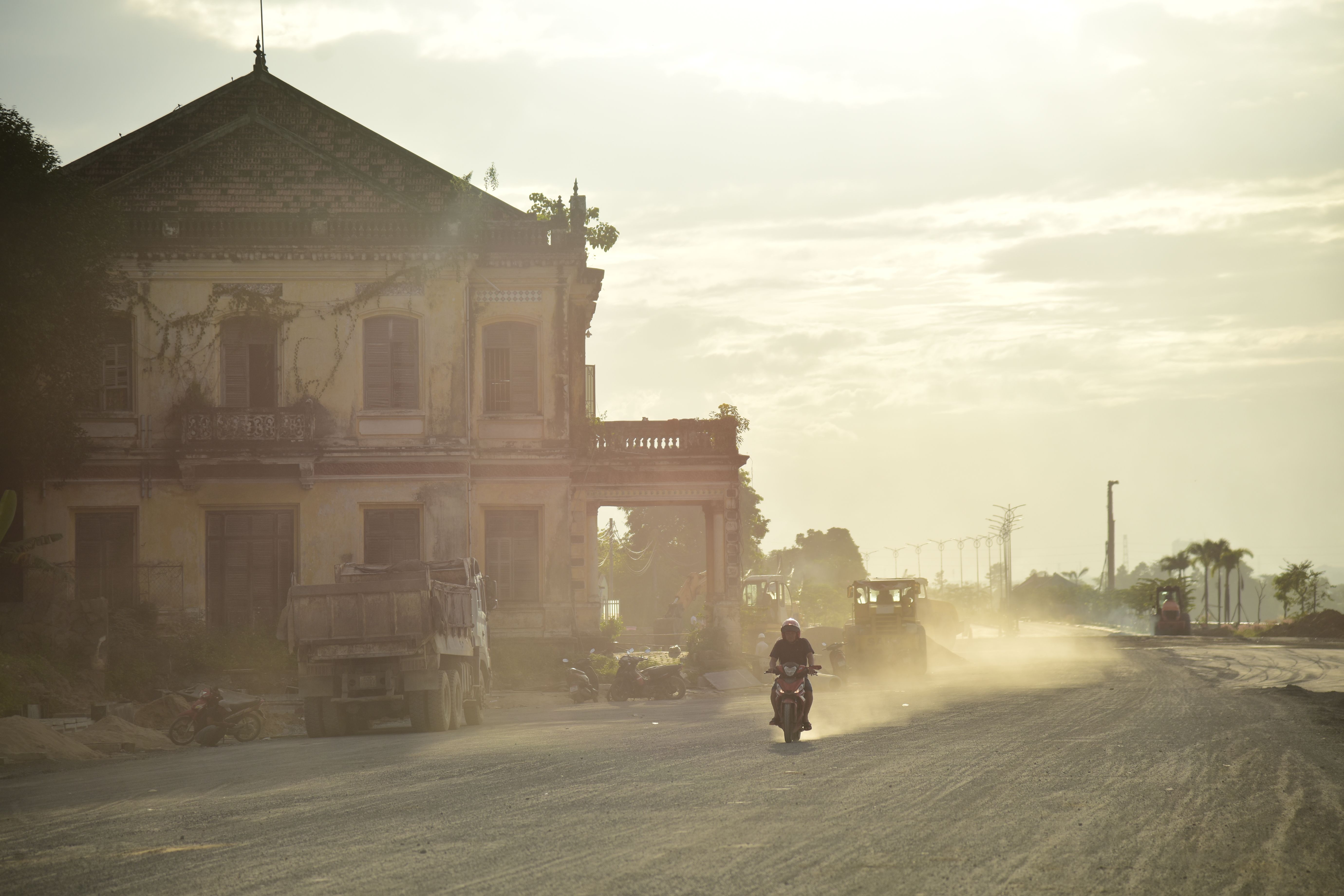 Sunlit Dusty Road Near an Abandoned Building · Free Stock Photo