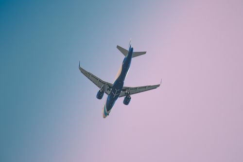 Free Image of an Airbus A320 NEO in final approach, flying against a colorful sunset sky. Stock Photo