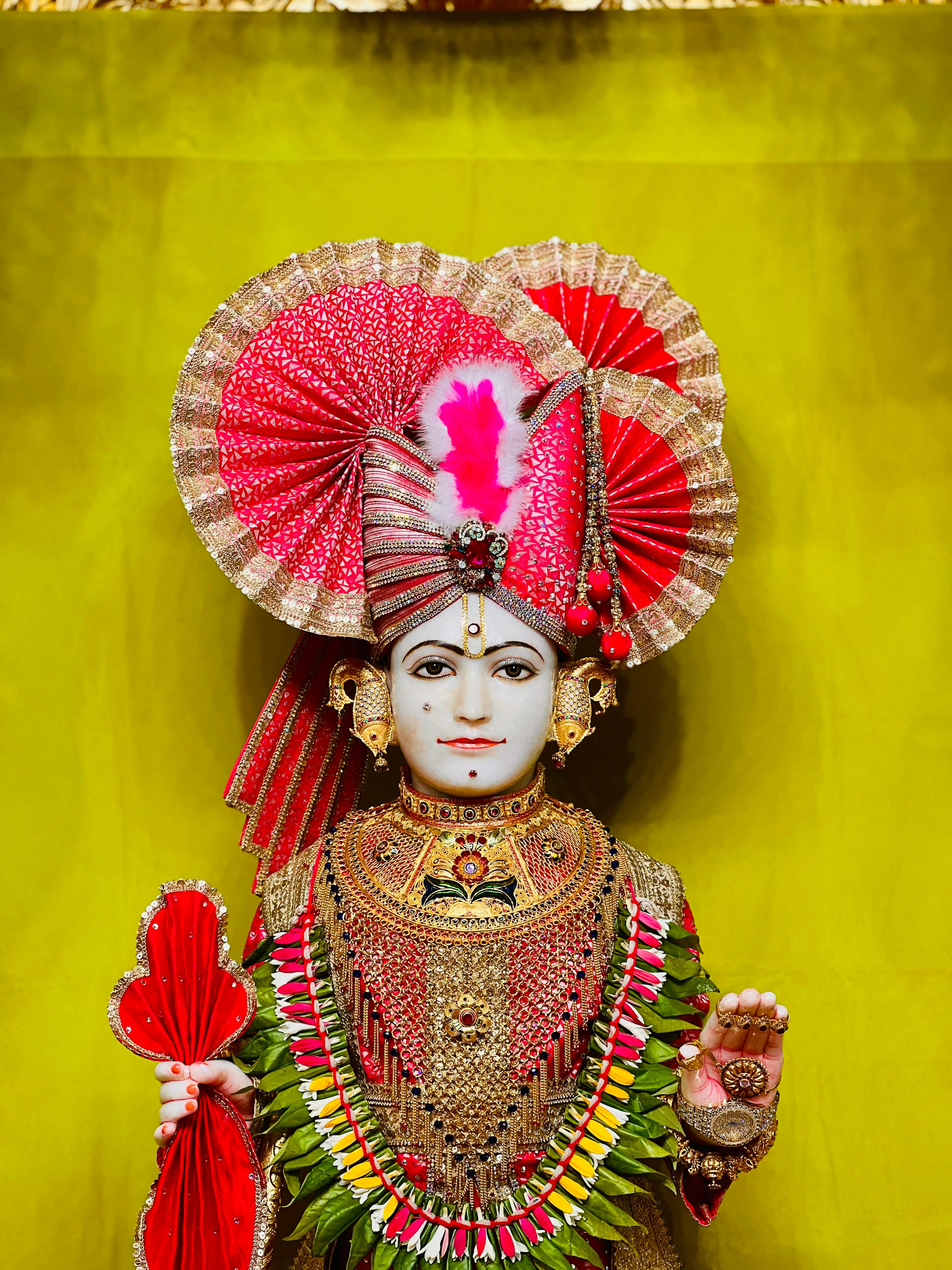 Colorful statue of a Hindu deity adorned with elaborate attire in Ahmedabad, India.
