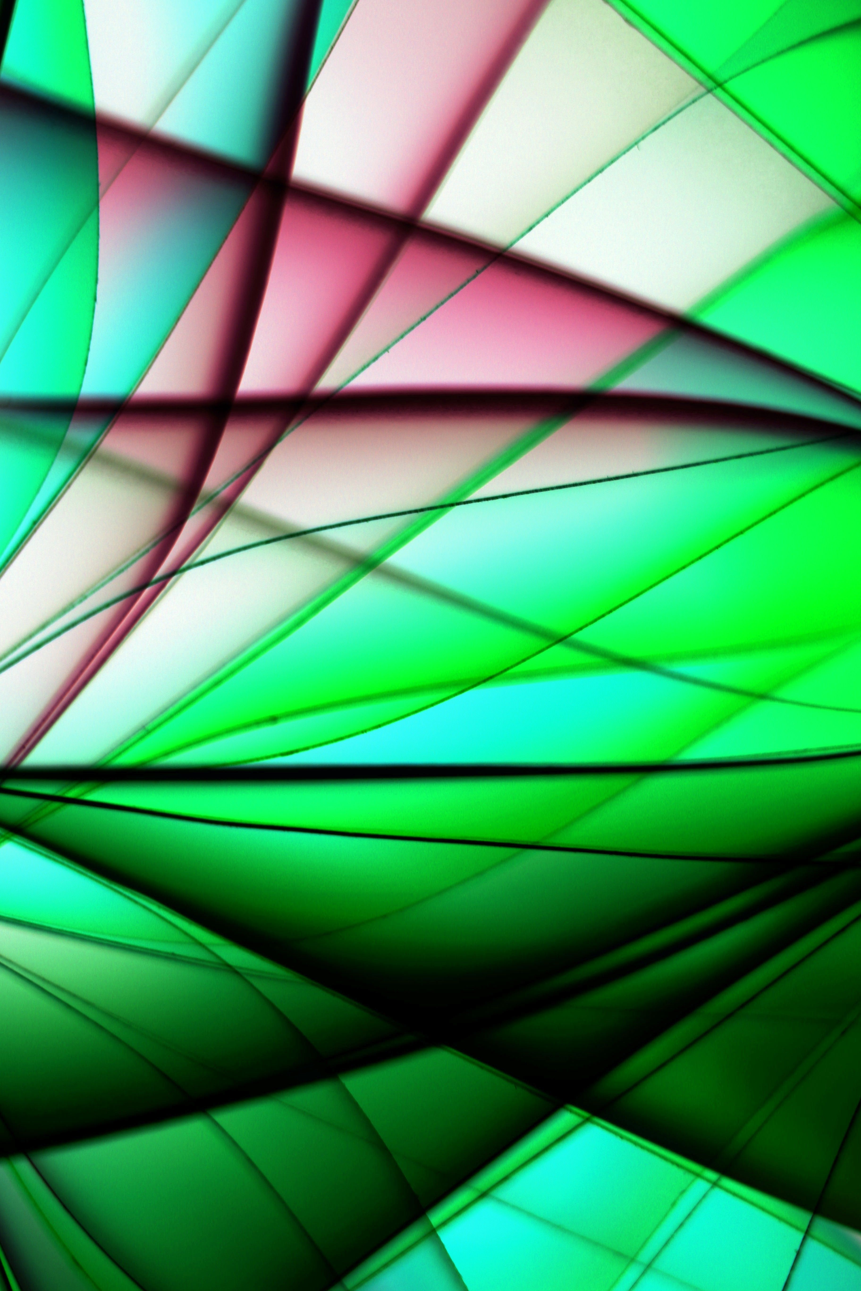Dynamic abstract image featuring intersecting green and pink lines in a vivid pattern.