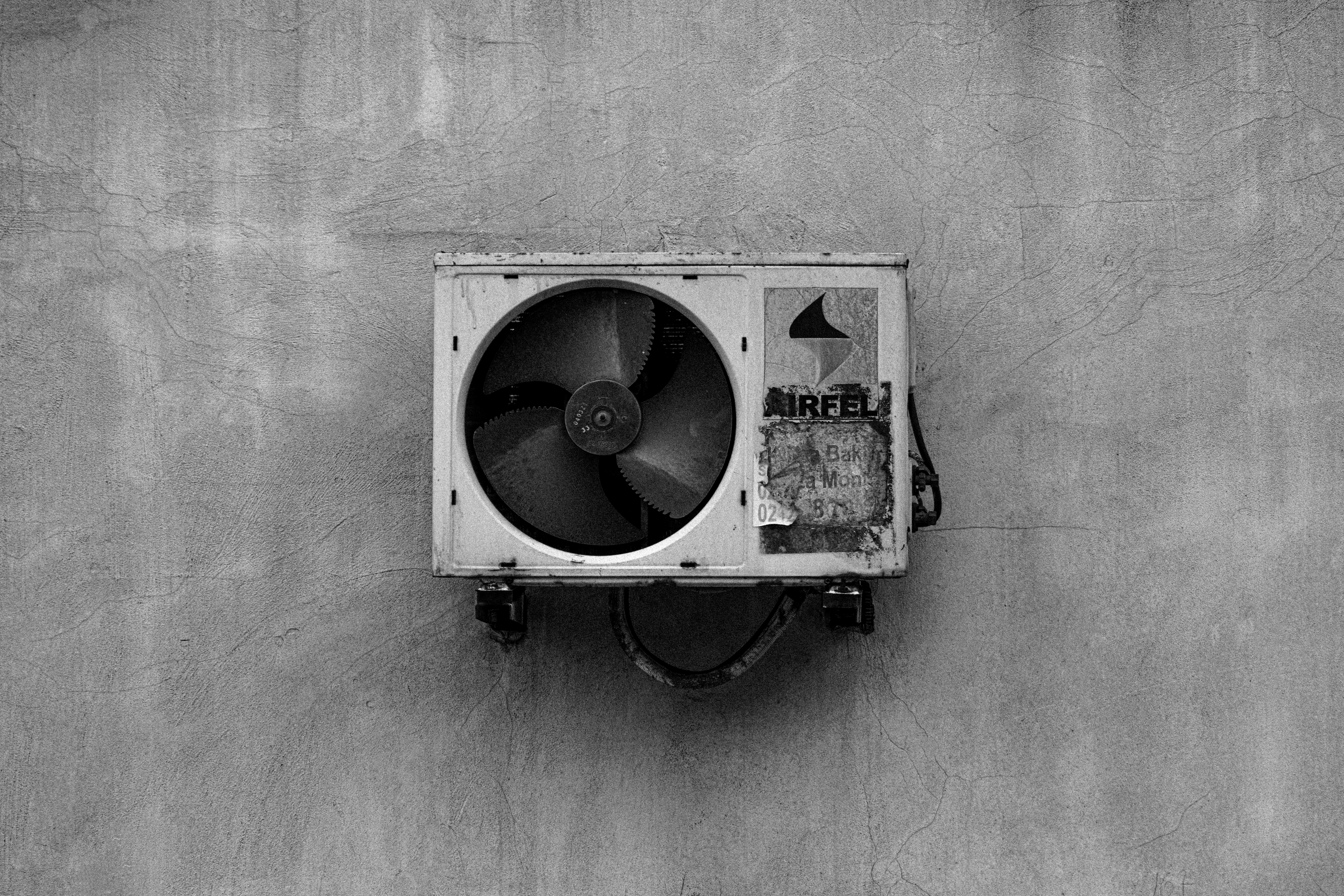Free Monochrome image of a wall-mounted air conditioner on a concrete surface. Stock Photo