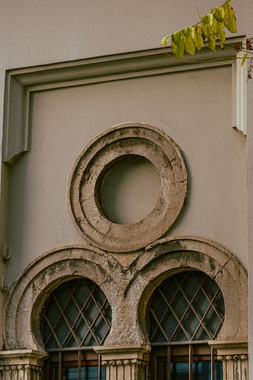 Free Close-up of vintage stone window architecture with ornate circular and arched designs. Stock Photo