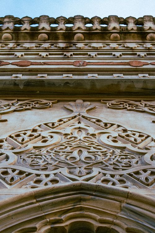 Free Intricate Gothic-style stone carving detail on historic architecture captured from below. Stock Photo