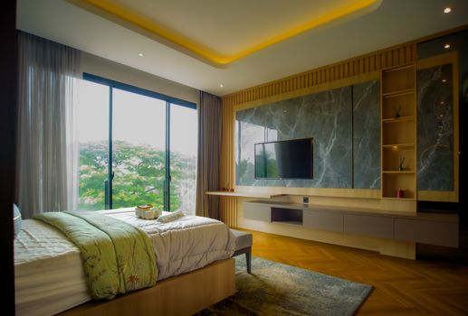 Elegant bedroom interior with large window and modern design elements, featuring a serene natural view.