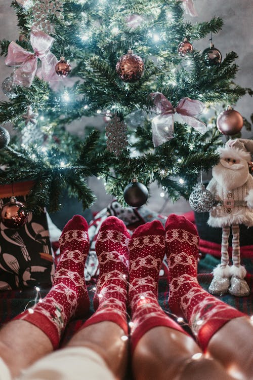 赤いクリスマスの靴下を履いているカップル