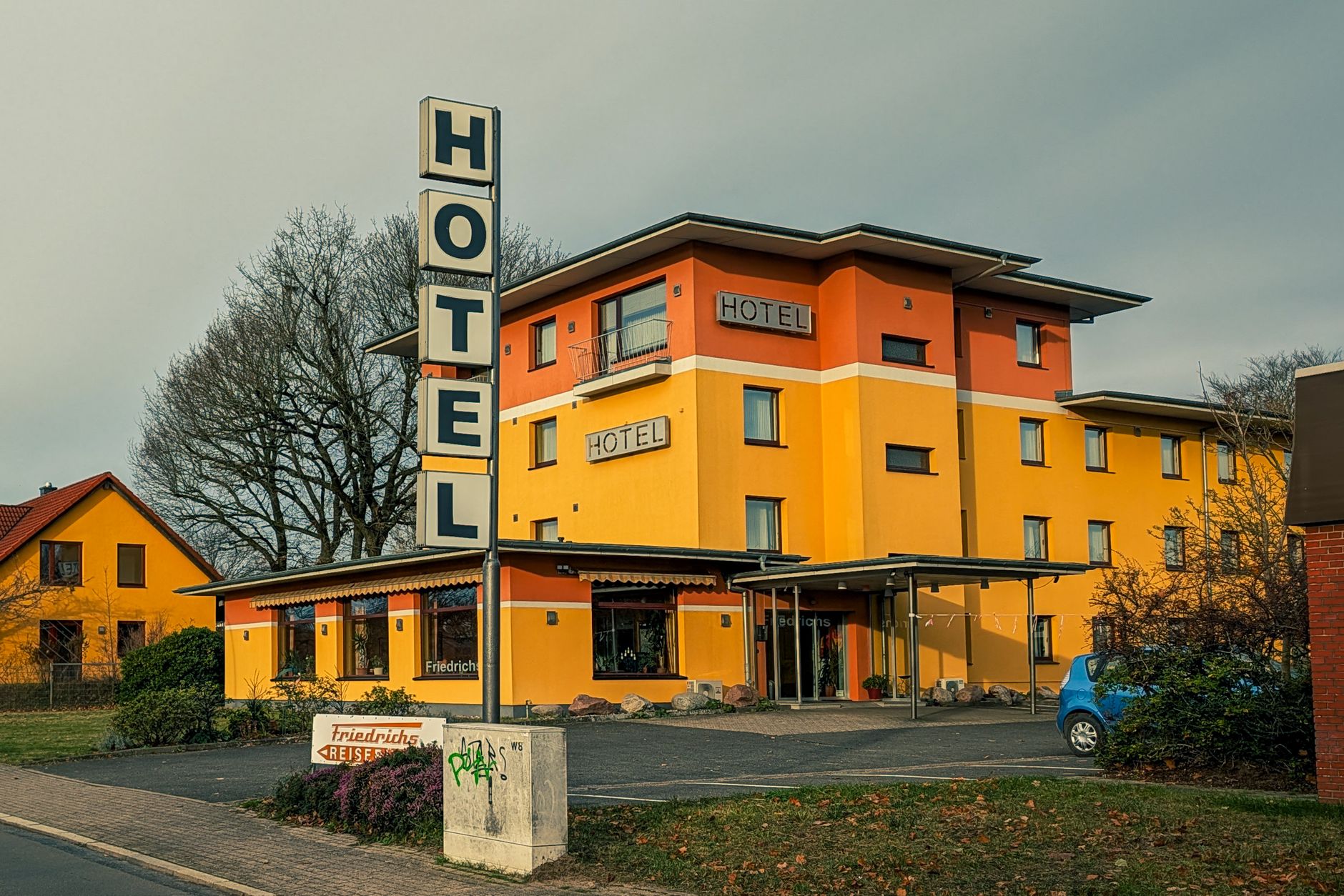 Yellow hotel exterior under a cloudy sky