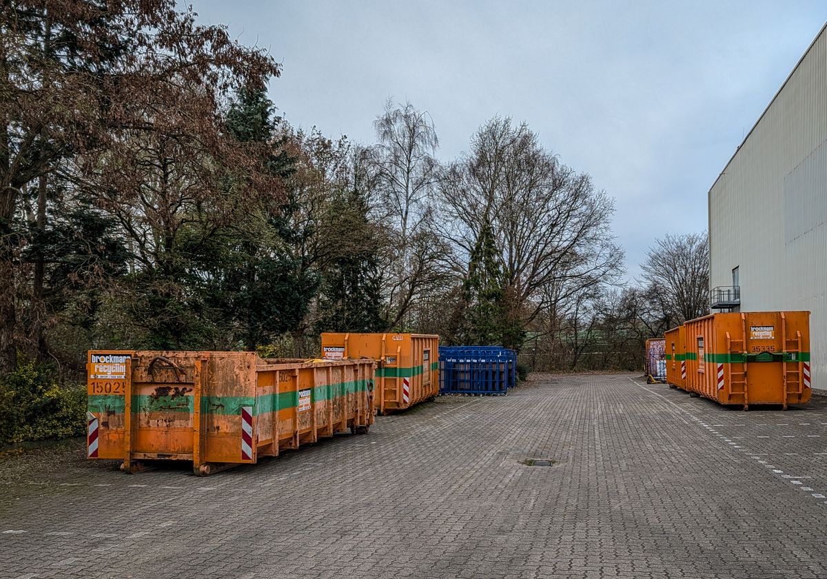 Row of industrial waste bins in an outdoor storage yard