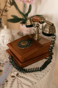 Elegant vintage rotary phone on a lace-covered table with floral decor