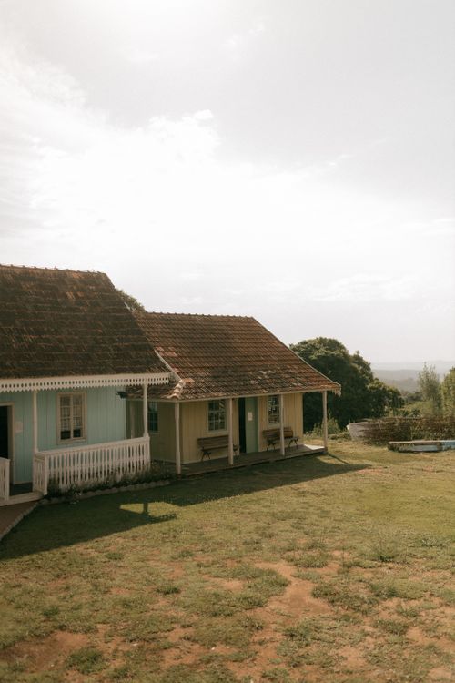 Free Scenic view of a quaint countryside cottage with a sunny, serene backdrop. Stock Photo
