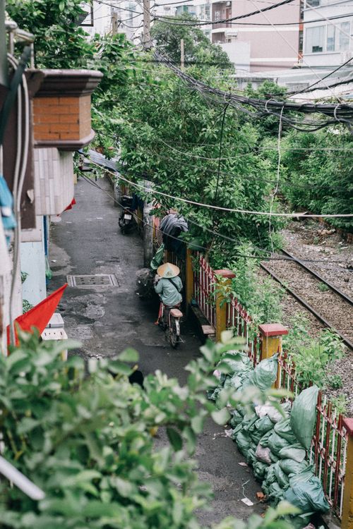 Narrow Urban Alley with Cyclist and Railway · Free Stock Photo
