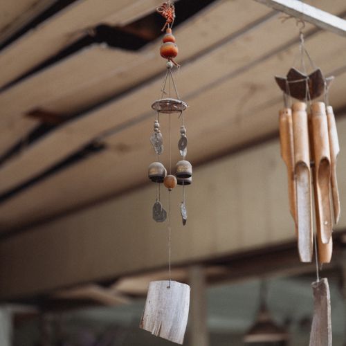 Free Close-up of rustic wooden and metal wind chimes hanging indoors, creating a serene ambiance. Stock Photo