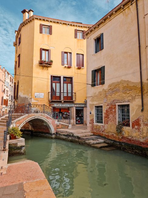 Picturesque canal with traditional architecture and bridge in Venice, Italy.