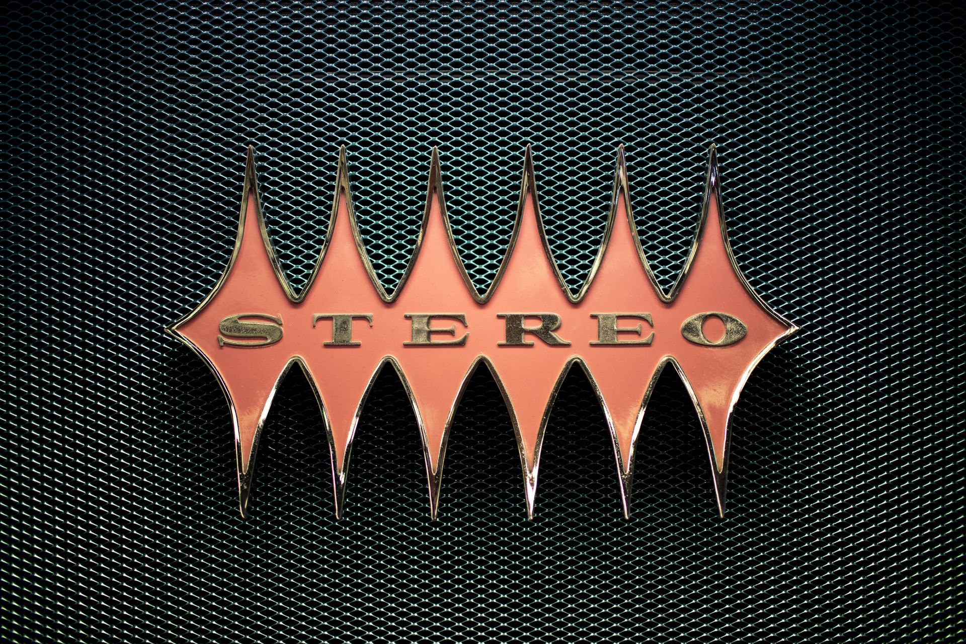 Close-up of a vintage stereo emblem on a textured mesh background.