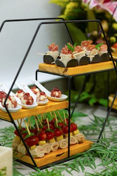 Beautifully arranged gourmet appetizers on a stylish catering stand, perfect for events.