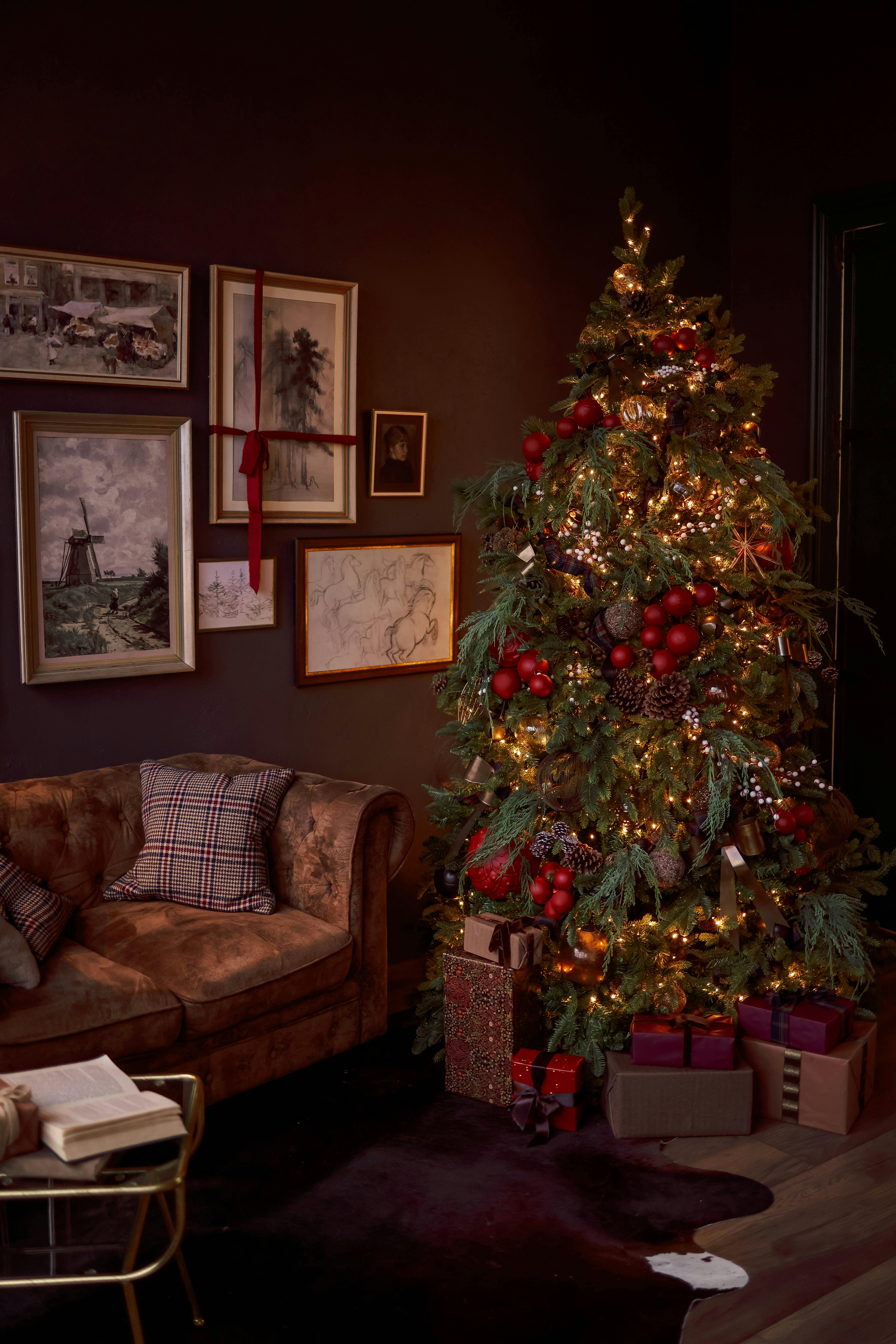 A warm and festive living room with a beautifully decorated Christmas tree and gifts.
