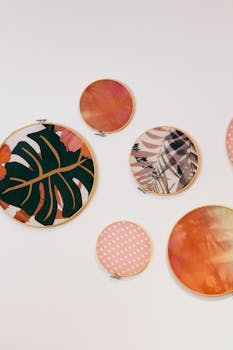 白色墙壁上，圆形刺绣环充满活力地展示着抽象和植物图案