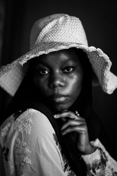 Black and white portrait of a woman in a wide-brimmed hat, exuding elegance.