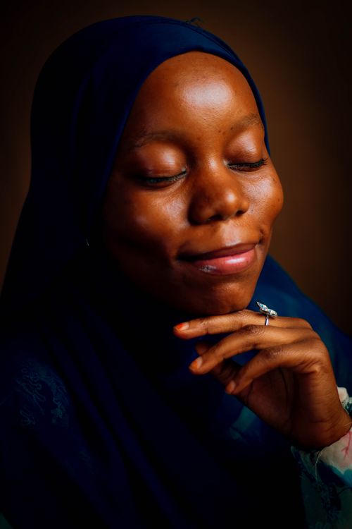 Free A serene portrait of a woman in a dark hijab with a peaceful expression, eyes closed. Stock Photo