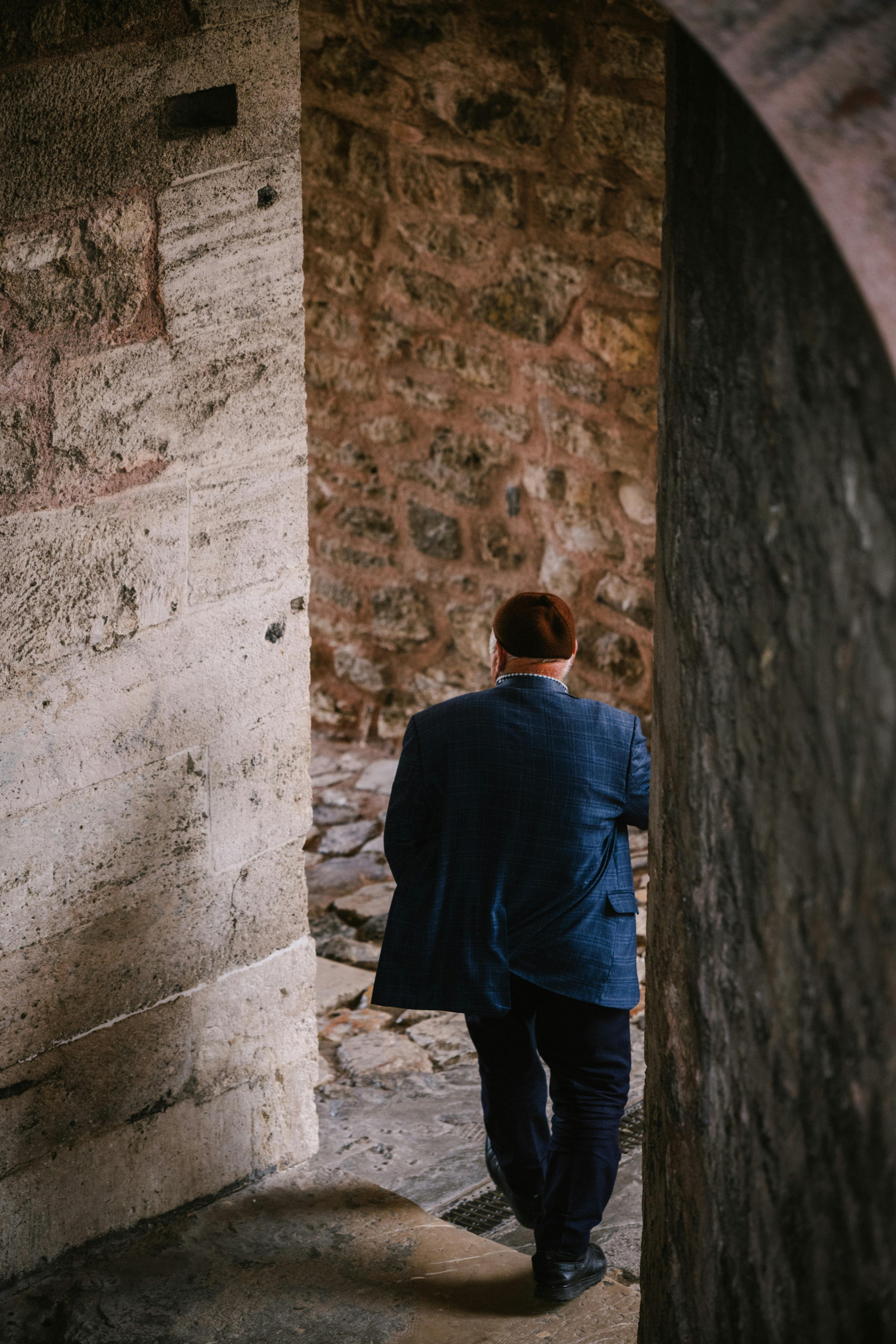 Adult male walking down a narrow stone passageway in Istanbul, Turkey, showcasing historic architecture.