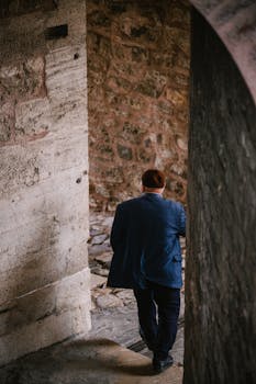 Adult male walking down a narrow stone passageway in Istanbul, Turkey, showcasing historic architecture.