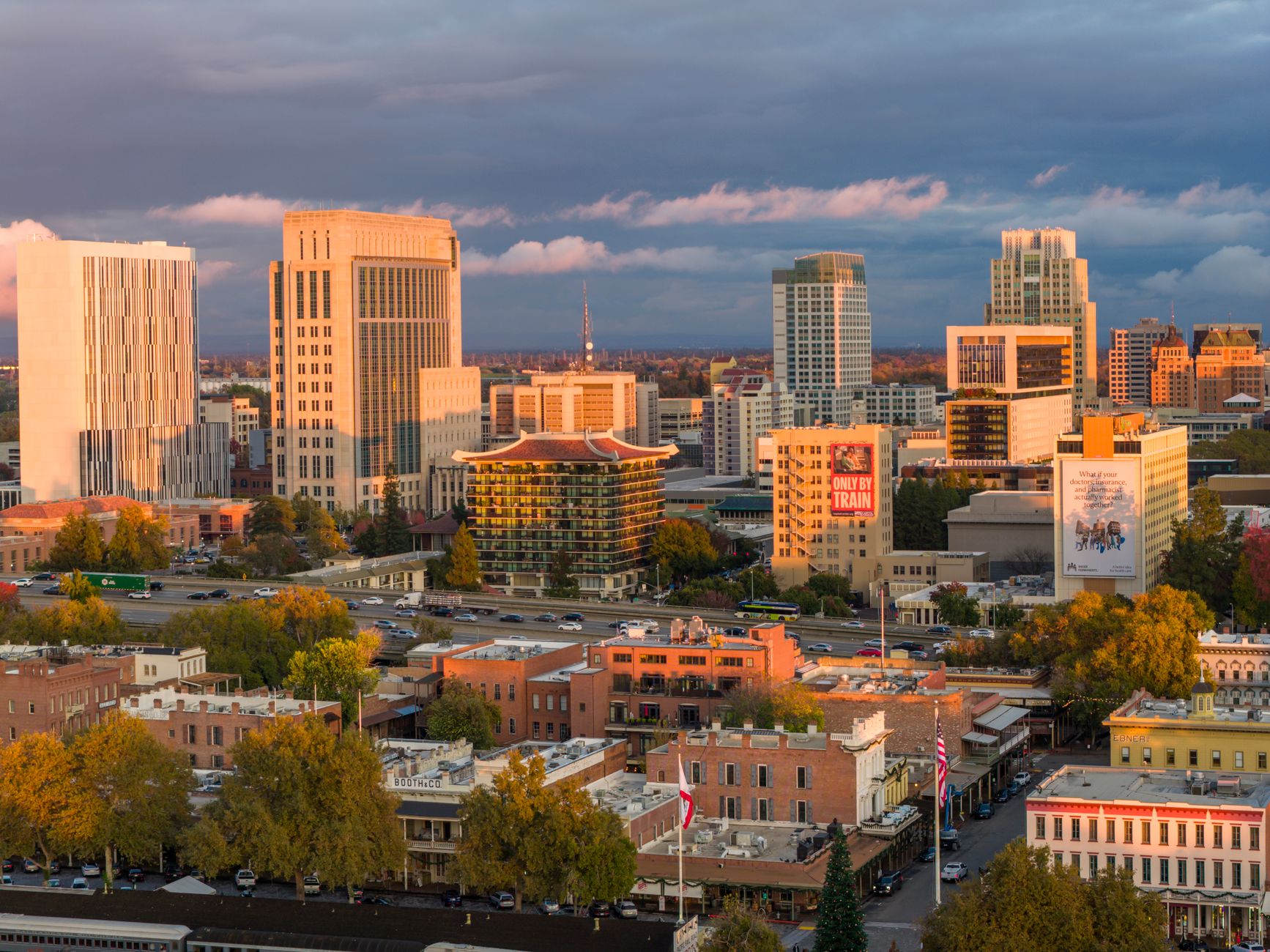 Aerial view of Sacramento's downtown skyline at sunset with vibrant autumn foliage.