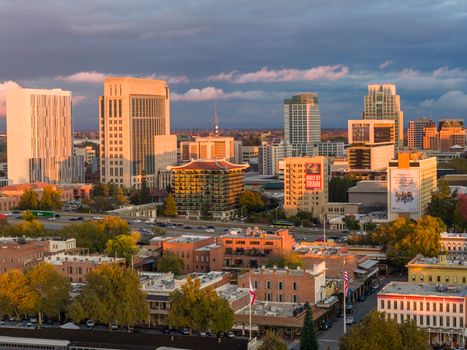 Aerial view of Sacramento's downtown skyline at sunset with vibrant autumn foliage.