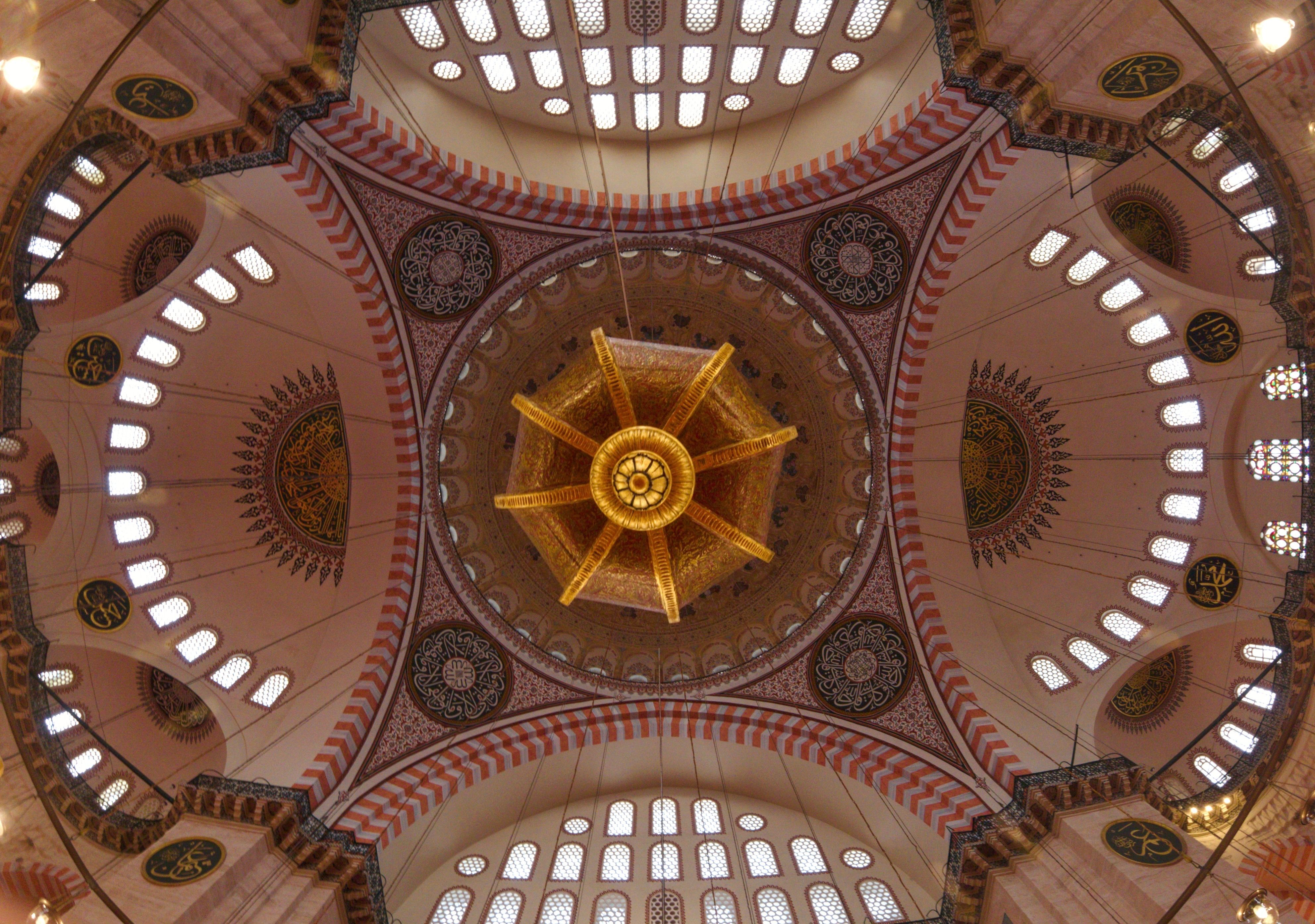 Looking up at the Suleymaniye Mosque's ornate dome in Istanbul, full of intricate patterns.