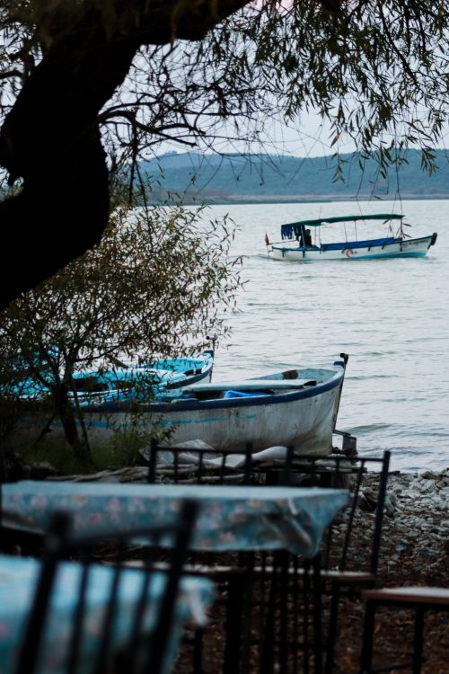 Free Peaceful lake view with boats and trees in Bursa, Türkiye. Tranquility captured. Stock Photo
