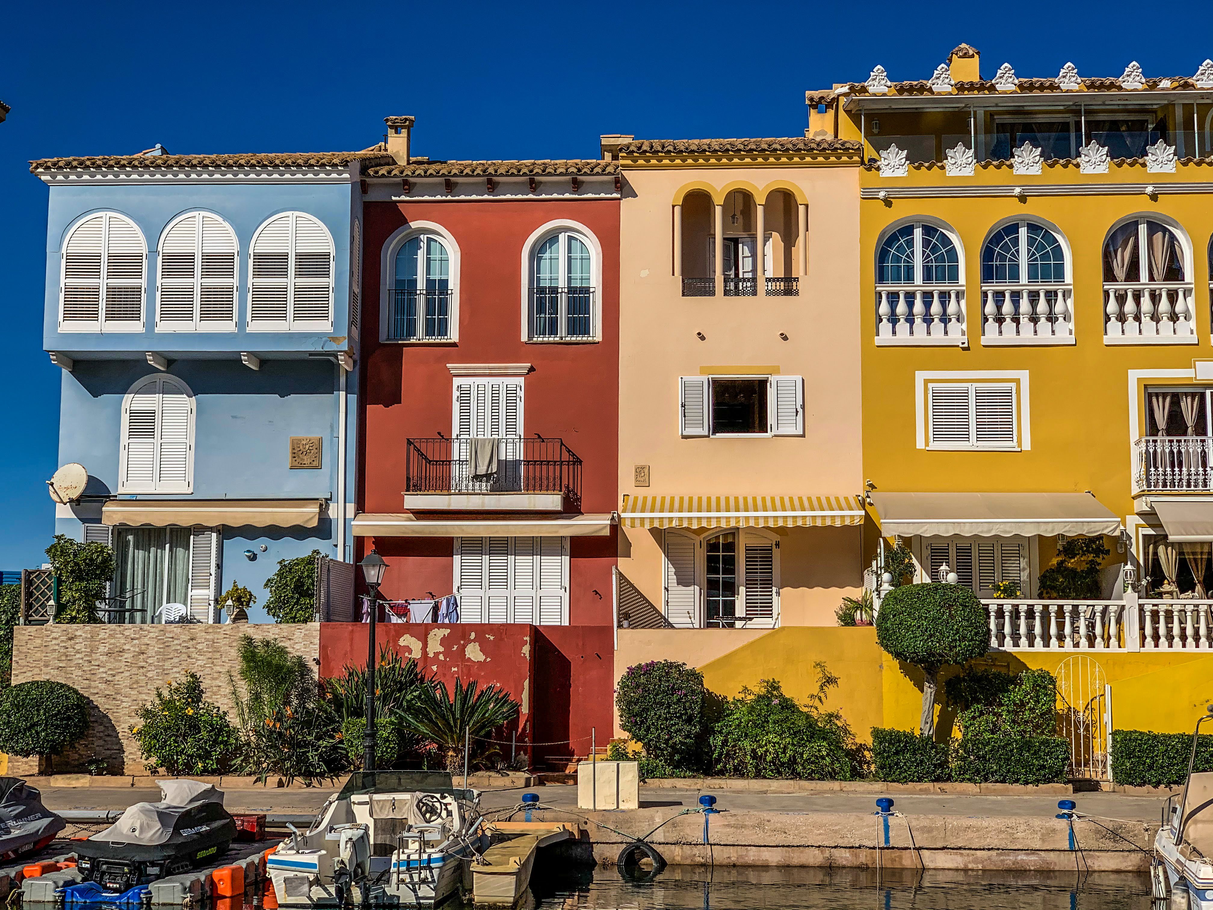Vibrant, picturesque Mediterranean-style homes by the waterfront on a sunny day.